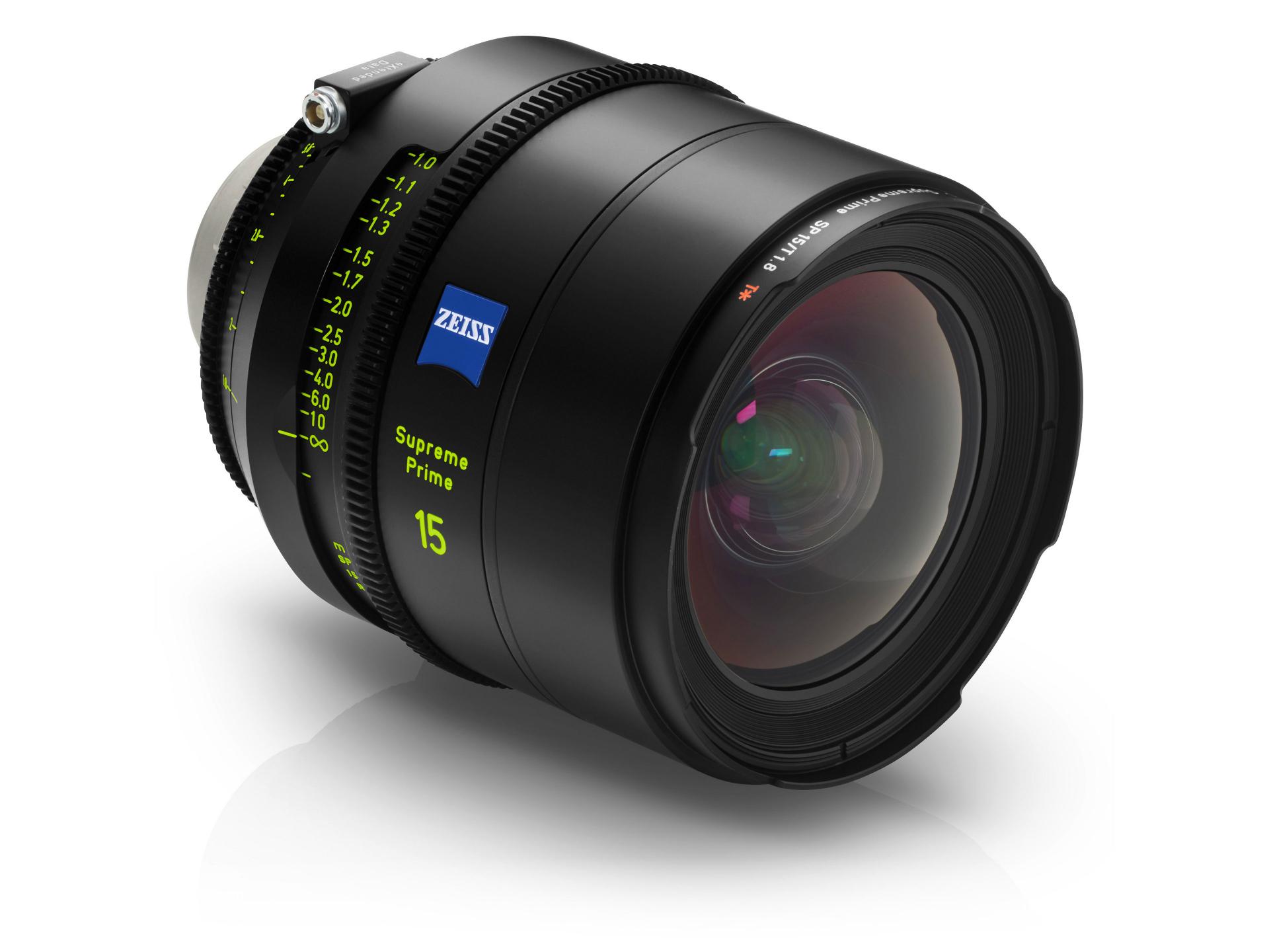 A ZEISS Supreme Prime 15mm camera lens is shown at an angle, highlighting its focus markings, glass elements, and ZEISS branding.