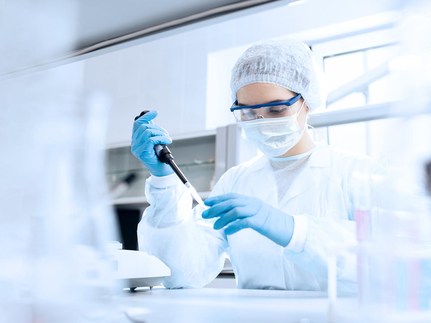 制药公司的员工在实验室中用移液管转移液体