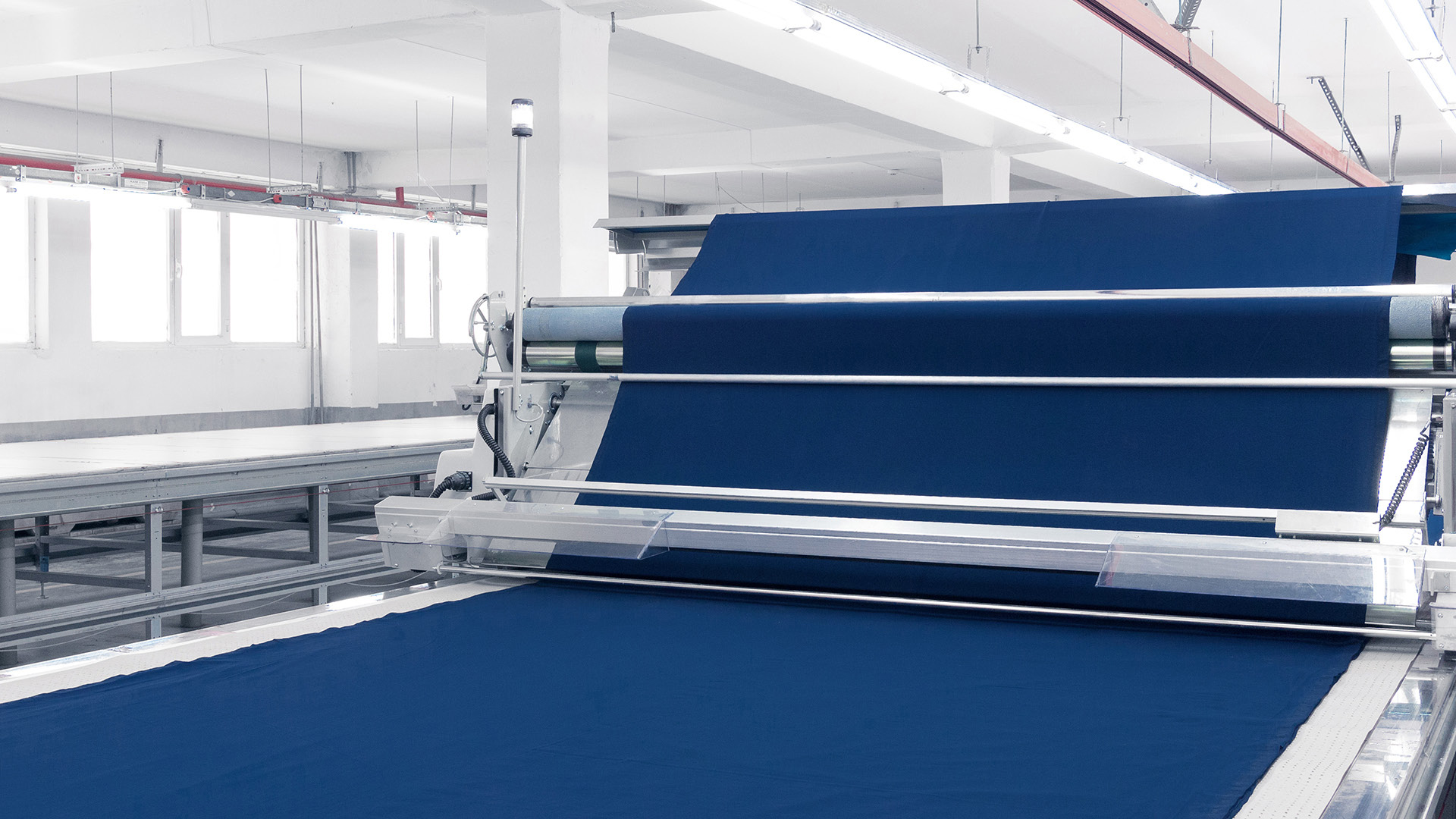 镀膜织物在在纺织厂的大型传送辊上移动