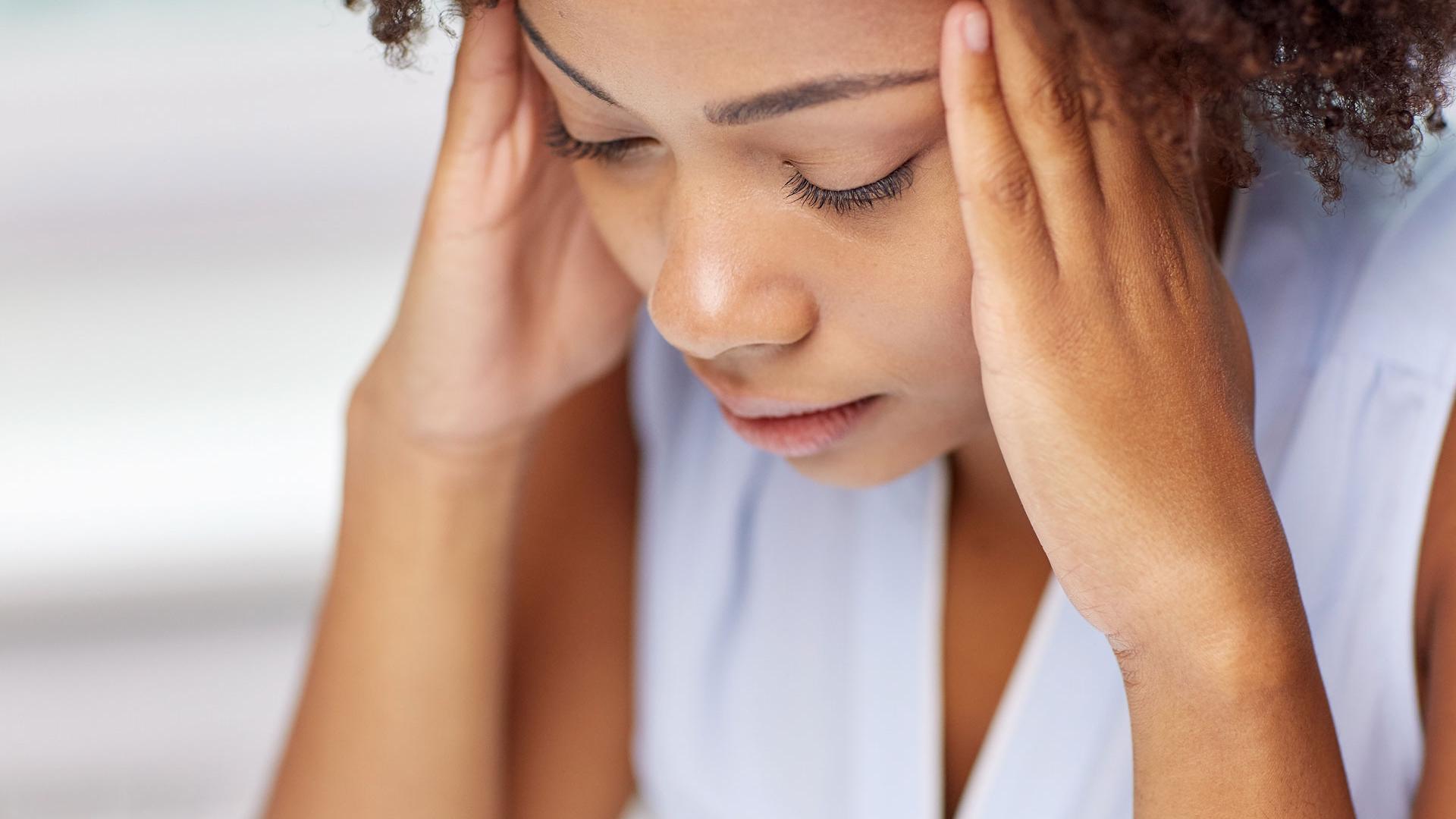close up of african young woman touching her head
