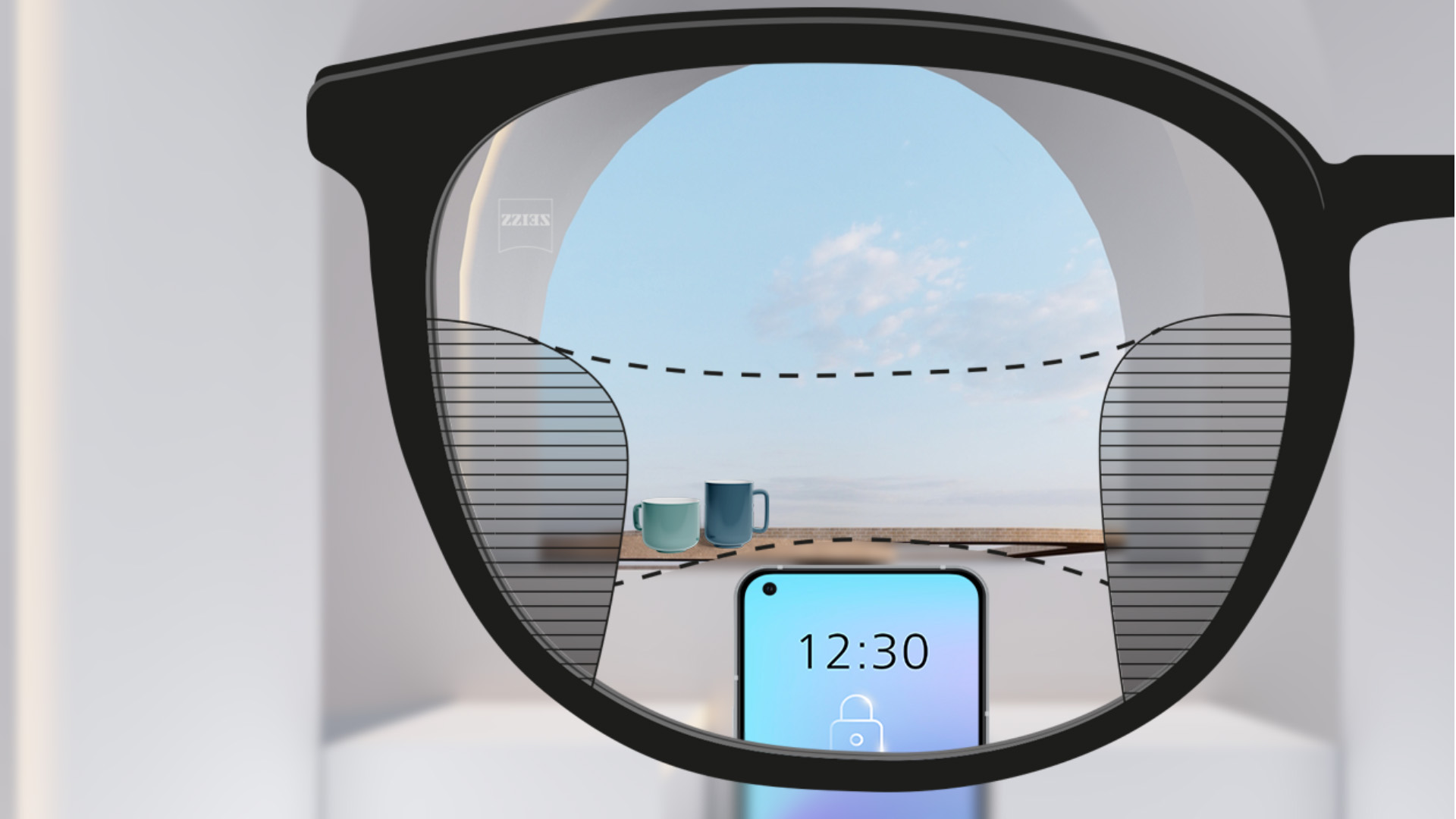 配戴蔡司智锐渐进镜片的第一人称视角示意。眼前是一台智能手机，远处是一只杯子，镜片视觉清晰，左右两侧的细长区域稍有模糊。