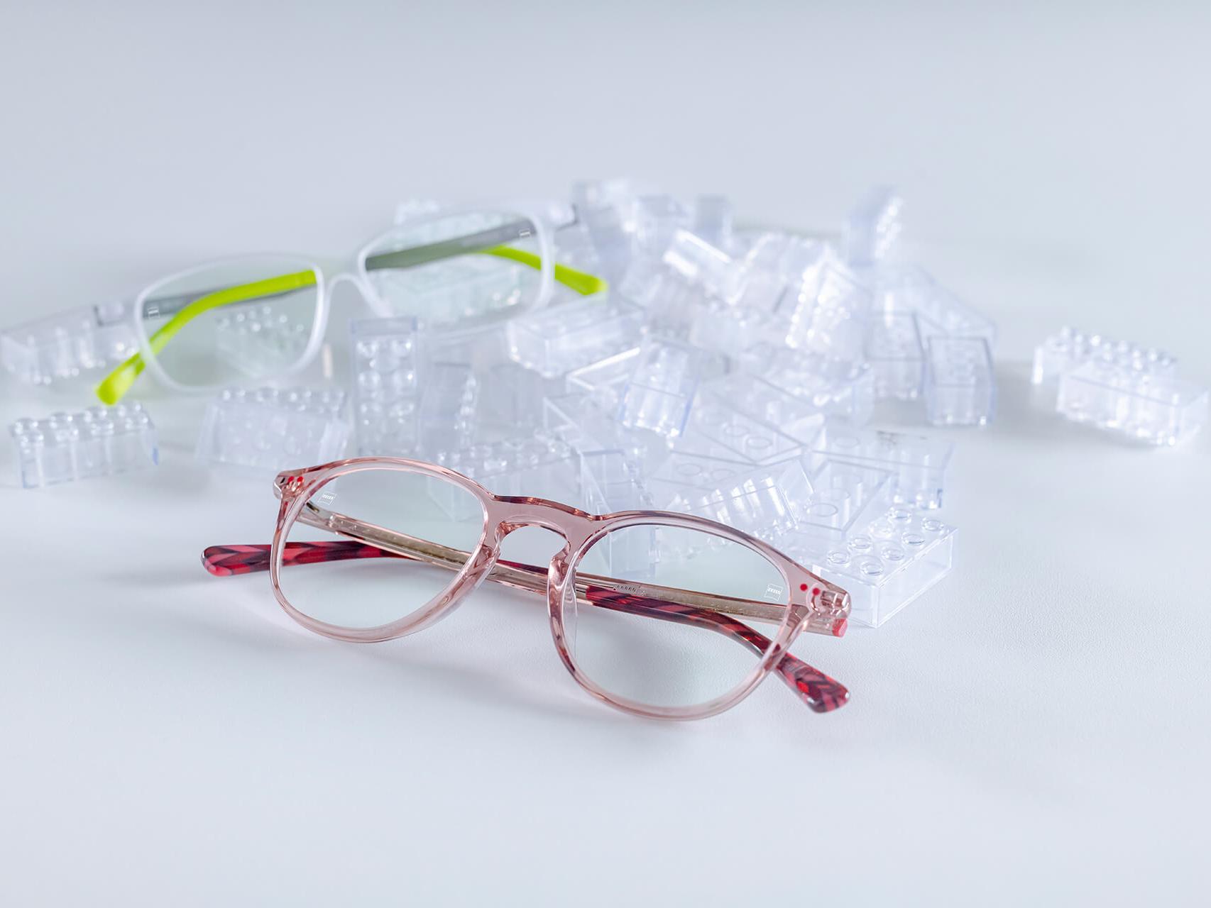 两副采用了蔡司钻立方爱动膜镜片的眼镜 眼镜放置于透明的玩具积木之间。