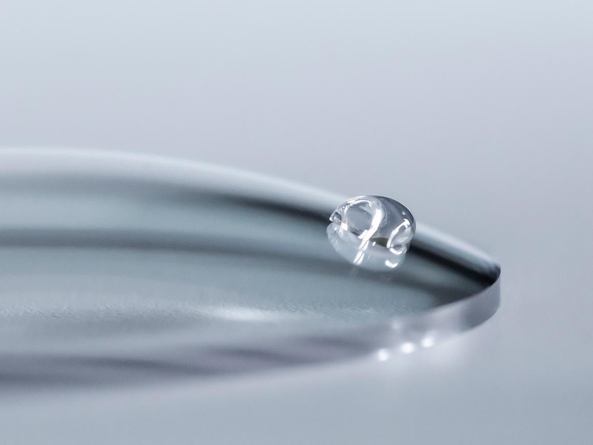 一滴水在使用了易清洁镀膜的蔡司镜片上滑落。