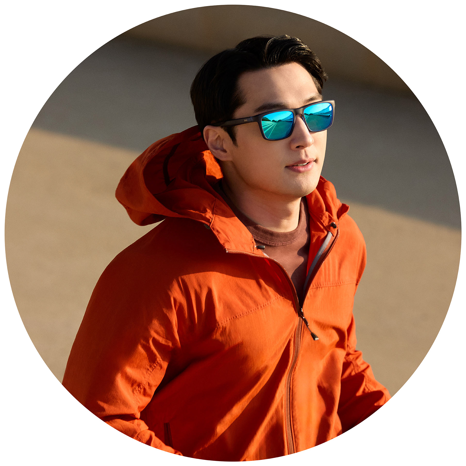 一位身穿橙色夹克的慢跑者配戴着镀有蓝色镜面镀膜的蔡司处方太阳镜。