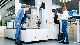 3 people standing around a coordinate measuring machine from the ZEISS PRISMO family.  