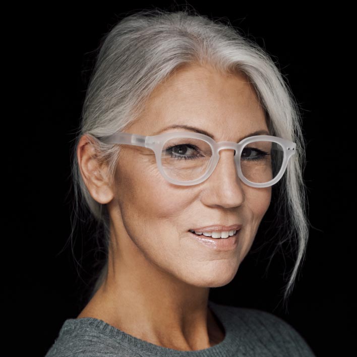 白发女性配戴着配有蔡司智锐渐进镜片的白框眼镜。几何面部扫描展现脸部结构以及镜框测量。